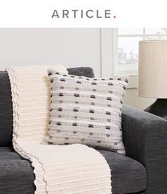 a gray couch with two pillows and a white blanket on it that says, how to crochet an article