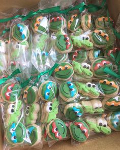 there are many decorated cookies in the box with green ribbons around them and on top of each other