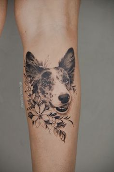 a black and white dog with flowers on it's leg is seen in this tattoo