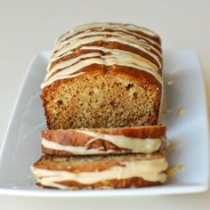 two slices of banana bread with icing on a white plate next to each other