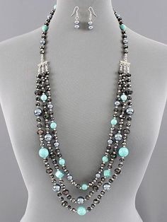 Beautiful triple layered beaded necklace with Turquoise dyed Howlite gems, grey pearls and black faceted crystals. Beads range from about 6mm-14mm. Pretty silver stations take this multi strand down to one for easy on and off over the neckline. Tons of beads on this and tons of sparkle! This ... Layered Beaded Necklace, Layered Beaded Necklaces, Stone Necklaces, Diy Collier, Lampwork Jewelry, Beading Ideas, Long Beaded Necklace