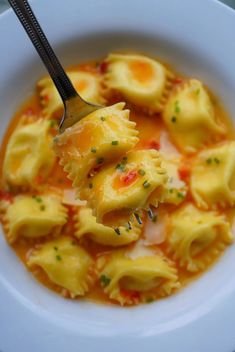 a white bowl filled with ravioli and sauce