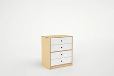 a white dresser with three drawers against a white wall and the bottom drawer is empty