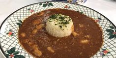 a plate topped with beans and rice covered in gravy