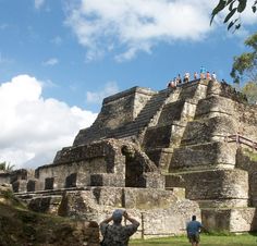 people are standing on top of an ancient structure in the jungle, while one person is taking a photo