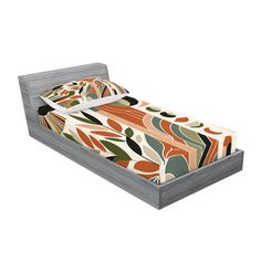 a bed with an orange and green bedspread sitting on it's side