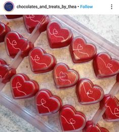 heart shaped chocolates in a plastic container on a counter top with the words love written on them