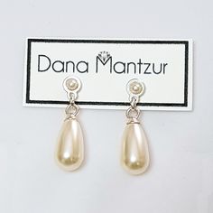 a pair of earrings with pearls hanging from them