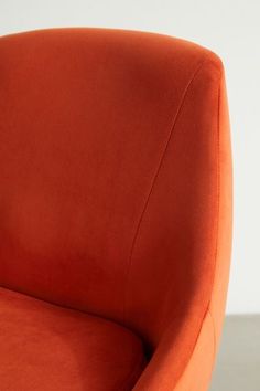 an orange chair sitting on top of a wooden table