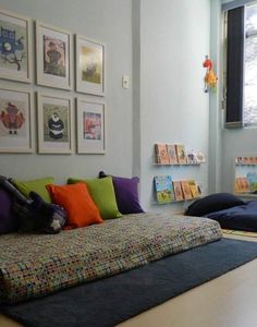 there is a bed with many pillows on it in the room next to bookshelves