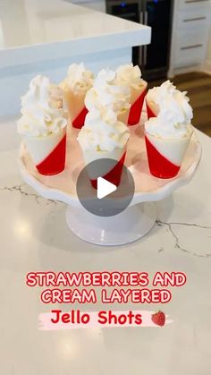 an image of strawberries and cream layered jello shots on a cake plate