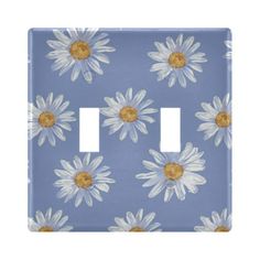 a light switch cover with white daisies on a blue background and two yellow centers