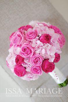 a bouquet of pink and white flowers in a clear glass vase on a burloom background