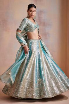 Turquoise and ivory zari embroidered lehenga in mirror work. Paired with embroidered choli and organza dupatta.
Component: 3
Pattern: Embroidered
Type Of Work: Mirror work, Zari work
Neckline: V neck
Sleeve Type: Sleeveless
Fabric: Tissue, Organza
Color: Blue,White
Other Details: 
Cutwork hem choli
Panelled lehenga
Occasion: Wedding, Reception - Aza Fashions Draping Styles, Mirror Work Lehenga, Indian Outfits Lehenga, Lehenga Designs Simple, Blue Lehenga, Indian Dresses Traditional, Indian Wedding Wear, Ghagra Choli, Blue Mirror