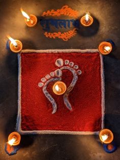 candles are lit on a red towel with the image of a person's foot