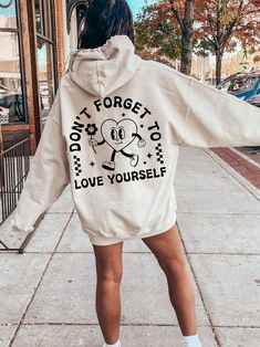 Don't Forget To Love Yourself Hoodie Our Gildan 18500 sweatshirt fits true to size. This shirt has a unisex fit, nice fit on women, but men should SIZE UP at least one size.  This unisex heavy blend hooded sweatshirt is relaxation itself. Made with a thick blend of cotton and polyester, it feels plush, soft and warm, a perfect choice for any cold day. In the front, the spacious kangaroo pocket adds daily practicality while the hood's drawstring is the same color as the base sweater for extra style points. .Other product features:  - Made with a medium-heavy fabric that consists of 50% cotton and 50% polyester for that cozy feel and warmth you need in a hoodie. -The classic fit along with the pouch pocket and the tear-away label make for a highly comfortable, scratch-free wearing experience Hoodies Cricut, Trendy Hoodie Designs, Affirmation Clothing, Aesthetic Self Love, Sweatshirt Fits, Hoodie Y2k, Trendy Aesthetic, Self Love Affirmations, Love Affirmations