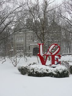 a large love sign in the middle of a snow covered park