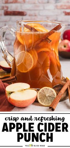 apple cider punch in a pitcher with cinnamon and apples