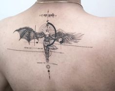 the back of a man's shoulder with an angel and compass tattoo on it