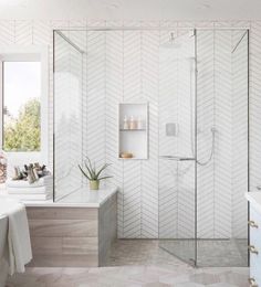 a bathroom with a walk in shower next to a bathtub and sink under a window