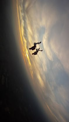 two people are flying in the sky with their feet up