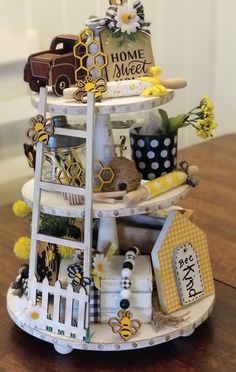 a miniature house made out of various items on a wooden table with a sign that says home sweet