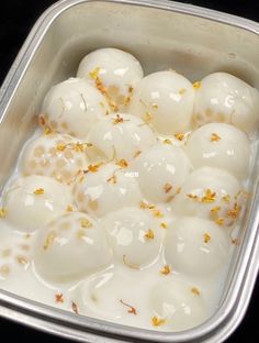 several eggs are in a metal container with orange flakes