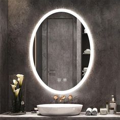 a bathroom with a round mirror above the sink