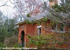 an old red brick house surrounded by trees