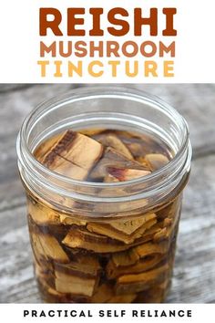 a jar filled with mushrooms sitting on top of a wooden table next to a sign that says reishi mushroom tincture