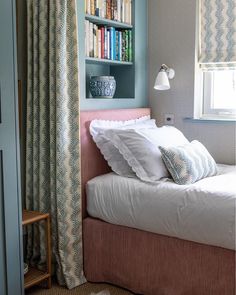 a bedroom with a bed, bookshelf and window