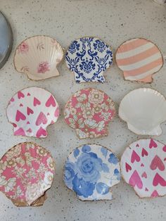 nine plates with hearts painted on them are sitting on the floor next to a bowl