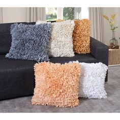 four different colored pillows sitting on top of a couch