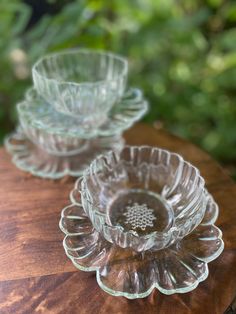 two glass dishes sitting on top of a wooden table