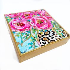 a painted box with pink flowers on it