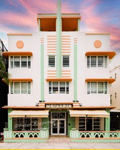 an art deco building with palm trees in the foreground and pink clouds in the background