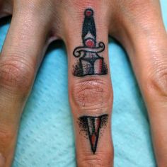 a person with a knife tattoo on their finger