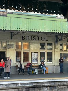 people are waiting at the train station for their luggage