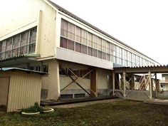 an old building with some windows on the side of it and grass in front of it