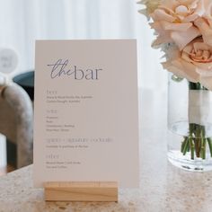 a table with a menu and flowers in a vase