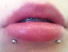 a woman's lips with piercings on the bottom and bottom part of her lip