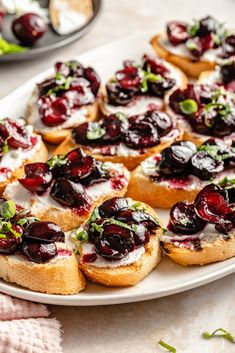 cranberry bruschets with cream cheese and green garnish on a white plate