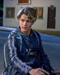 a young man riding on the back of a motorcycle