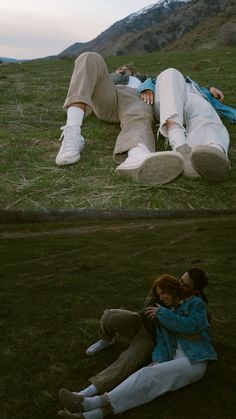 two people are laying on the grass and one is hugging