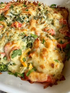 a casserole dish with broccoli, cheese and other toppings on it