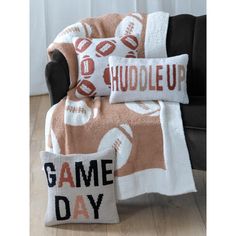 a blanket and pillow on a chair with the words game day written in red letters