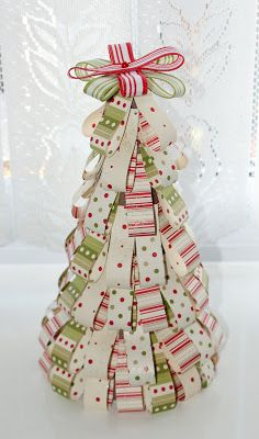 a small christmas tree made out of strips of paper with bows and ribbons on it