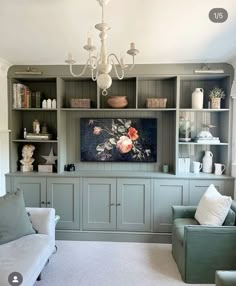 a living room filled with furniture and a chandelier hanging from the ceiling above it