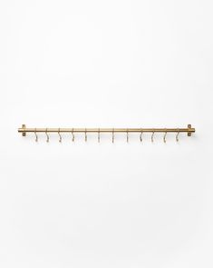 a gold coat rack with five hooks on it