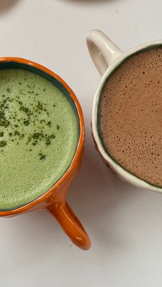 two mugs of green tea sit next to each other on a white counter top